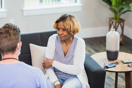 Female patient discusses arm pain with healthcare professional
